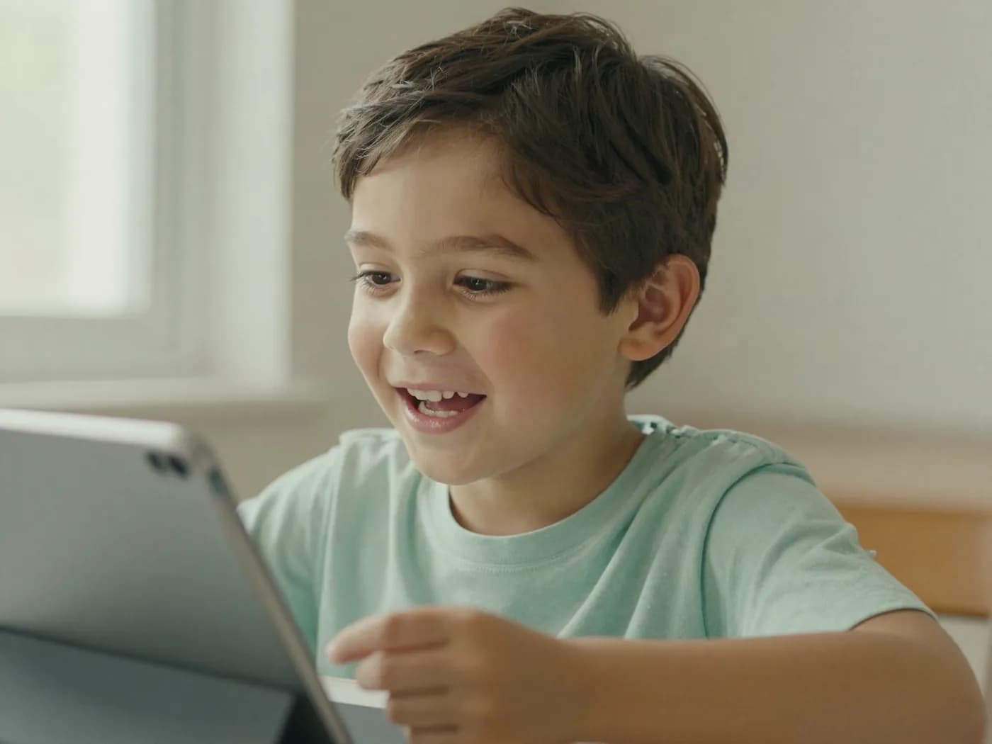 A young child speaking clearly toward a tablet during a guided speech activity